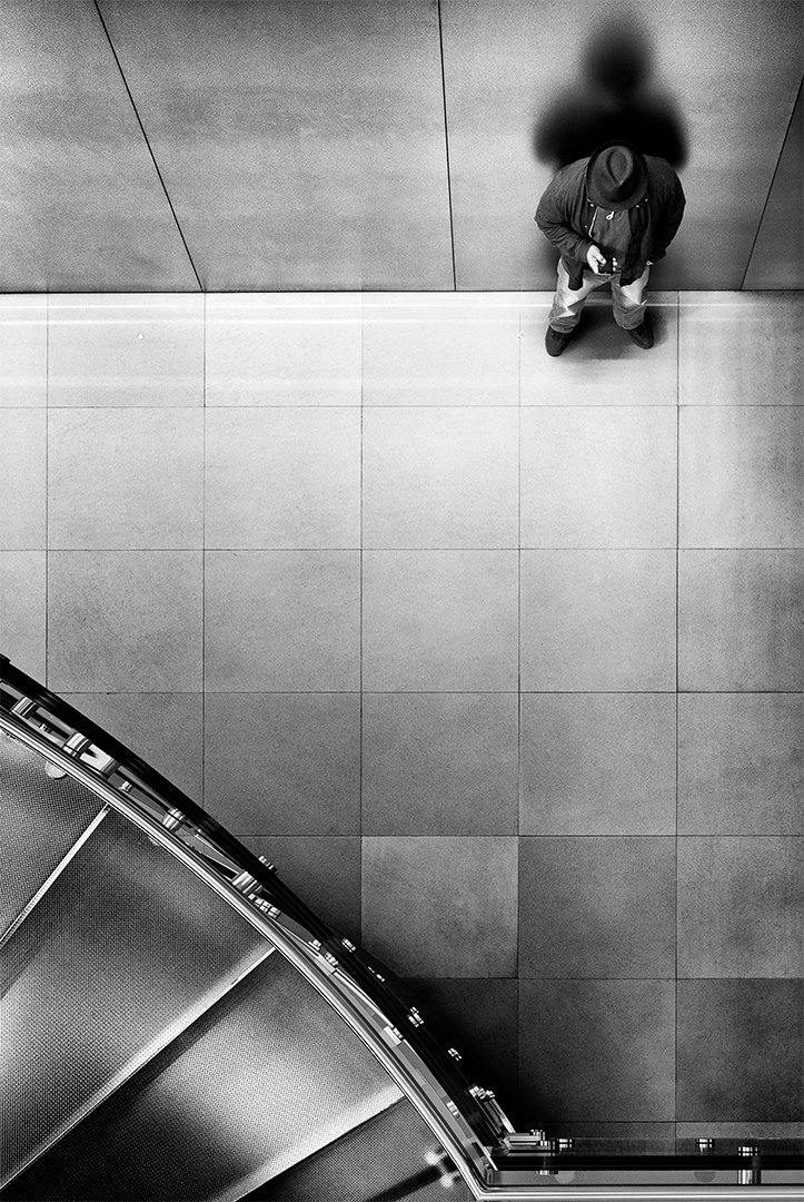 Una persona vista desde arriba junto a una escalera curva.
